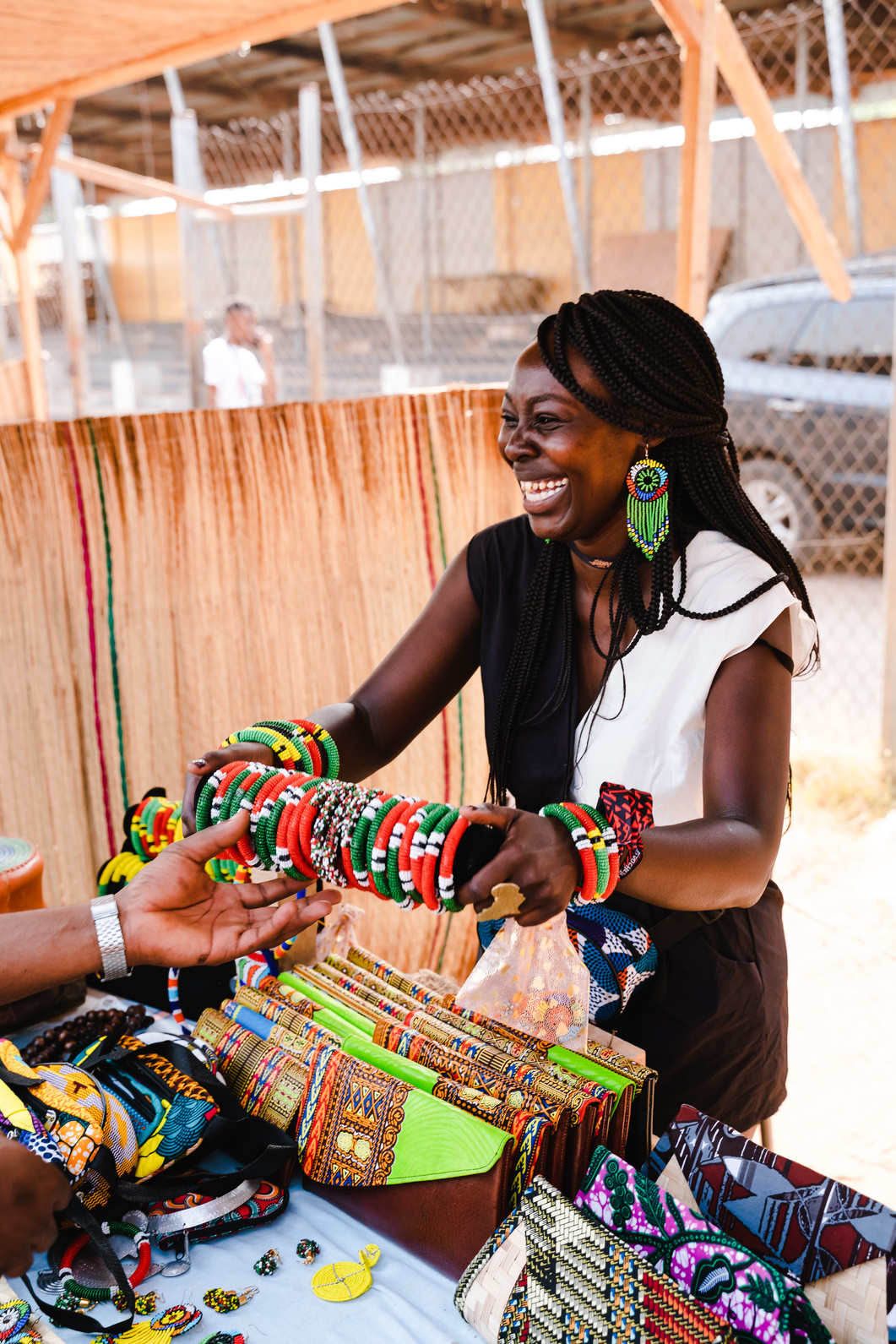 Happy Woman Selling Colorful Bracelets and Wallets
